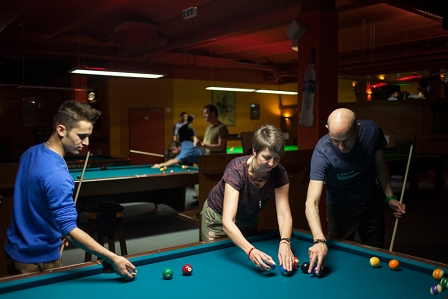 Flüchtlingspaten und ihr "Patenkind" beim Billiardspielen